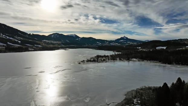 Aerial photo with drone of frozen Gruentensee and Allgaeu Alps in winter
