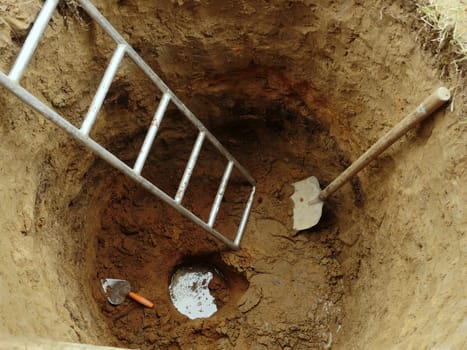 water well with hand construction tool ground top view, water has appeared at the bottom