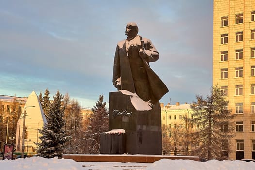 monument of Vladimir Lenin against the background of the city dusted with snow in winter. High quality photo