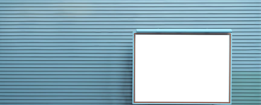 Empty indoor advertising display board on blue wall
