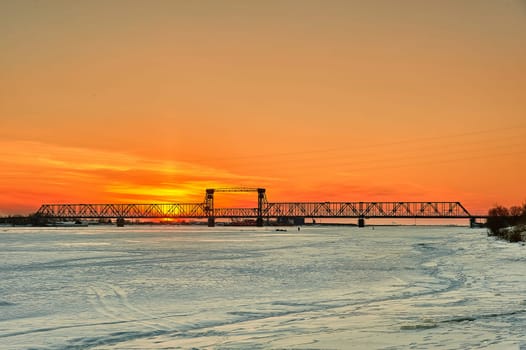 Sunset on the Severnaya Dvina river in Arkhangelsk with a bridge. High quality photo