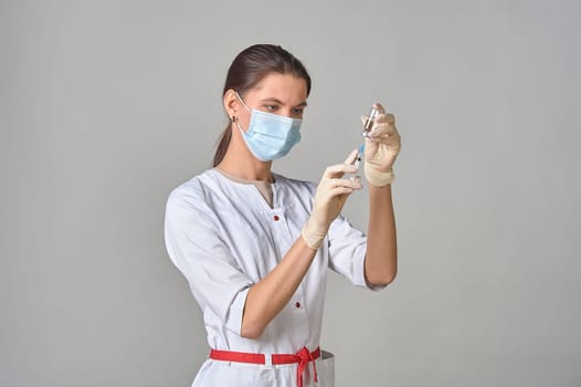 A nurse taking medicine into a syringe from a bottle close-up. . High quality photo