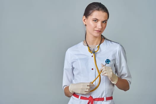 a young doctor in a white coat with a stethoscope around his neck. High quality photo