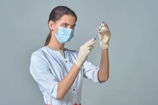 A nurse taking medicine into a syringe from a bottle close-up. . High quality photo