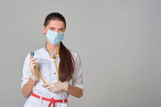 a doctor in a medical mask and white coat with a yellow stethoscope around his neck. High quality photo