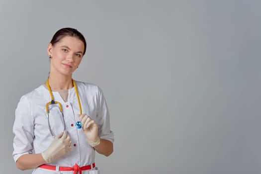 A young doctor in a white coat with a stethoscope, space for text. High quality photo