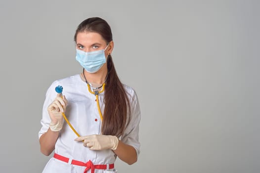 a doctor in a medical mask and white coat with a stethoscope around his neck. High quality photo
