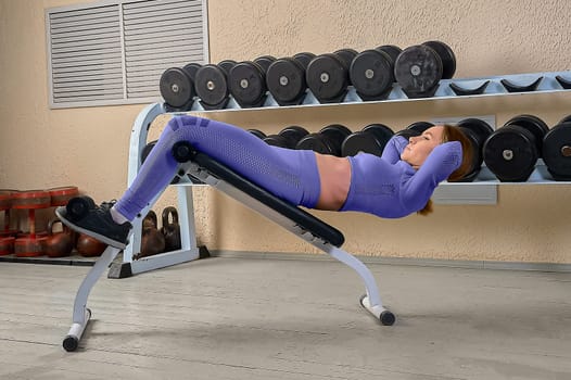A beautiful young woman shakes her abs on a bench in the gym. High quality photo