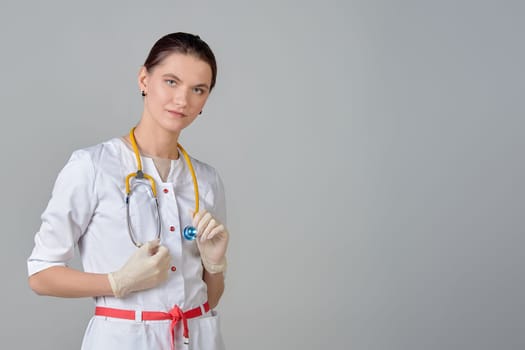 A young doctor in a white coat with a stethoscope, space for text. High quality photo