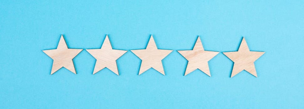Five stars on a colored background, hand put the last star in the row, rating, giving feedback