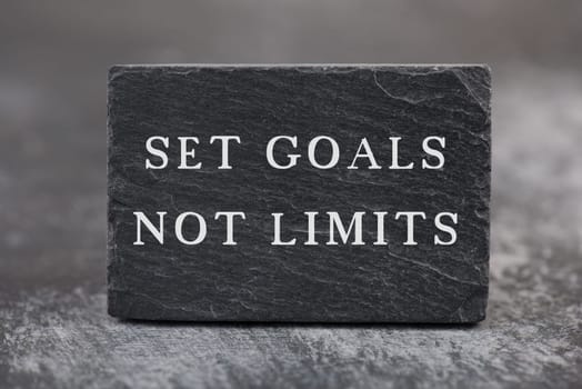 The phrase set goal not limits is standing on a textured background, business strategy, positive lifestyle