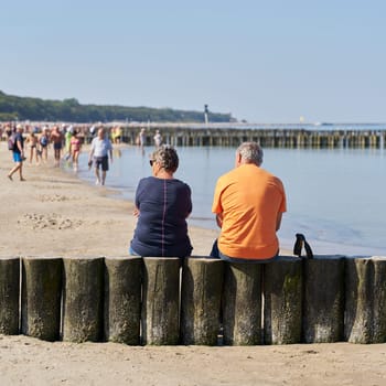 Couple on a breakwater on the beach of Kolobrzeg on the Baltic Sea in Poland