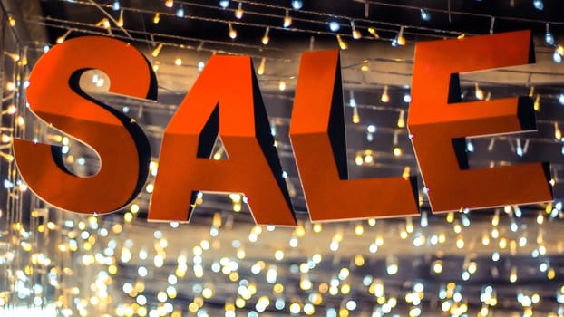 Store sale sign. Special offer banner with the red sale text gold bokeh blur background