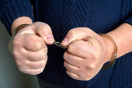 Men's hands in handcuffs close up. High quality photo