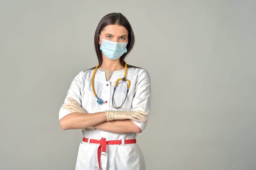 young doctor in a medical mask and white coat with a yellow stethoscope around his neck. High quality photo