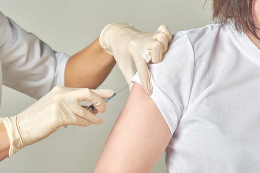 nurse gets vaccinated in the shoulder close-up. High quality photo
