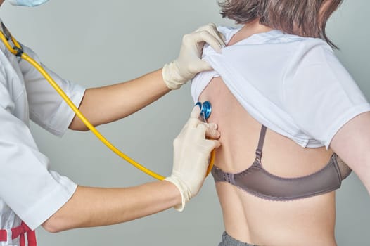 The doctor listens to the patient's lungs with a stethoscope. High quality photo