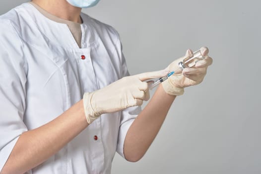 A nurse taking medicine into a syringe from a bottle close-up. Preparation of the coronavirus vaccine-Covid-19. The concept of vaccine prevention of covid-19. High quality photo