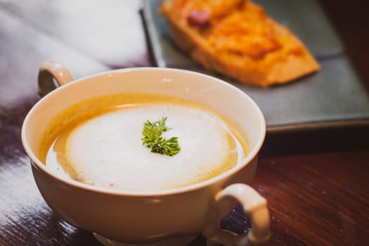 Mushroom Soup with Garlic Bread on ceramic plate on the wooden table.