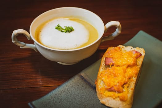Mushroom Soup with Garlic Bread on ceramic plate on the wooden table.