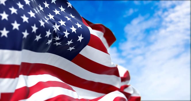 The national flag of the United States of America waving in the wind on a clear day. The flag has become a powerful symbol of Americanism
