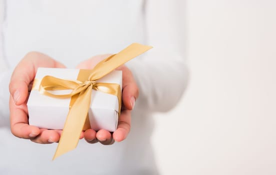 Valentine Day. Female beauty hands holding small gift package box present wrapped paper with ribbon isolated on white background, Christmas, New year, Birthday holiday background concept
