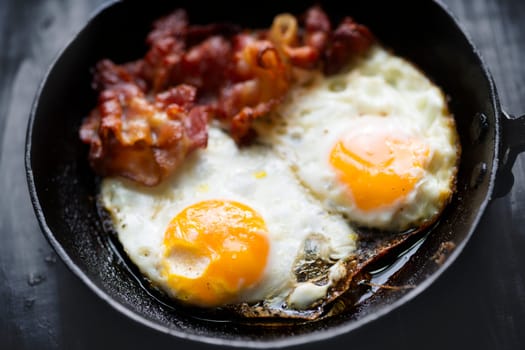 close up of pan of bacon fat  fried eggs breakfast