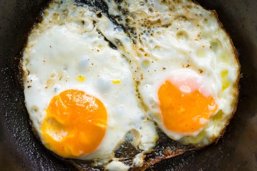 close up of pan of bacon fat  fried eggs breakfast