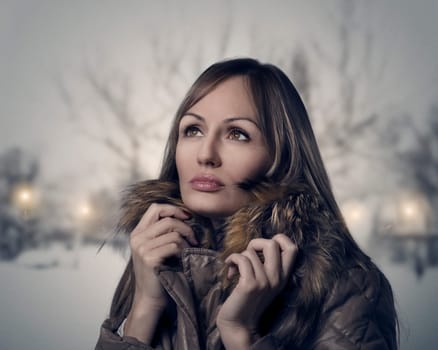 Woman walking in the park on a snowy evening