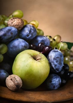 Autumn fruit in wooden plate
