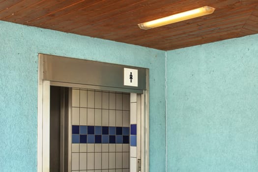 Women restroom near swimming pool, entrance with ladies toilet icon.
