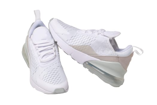 White sneaker isolated. Close-up of a pair white elegant stylish female leather high-heeled sport shoes isolated on a white background. Womens shoe fashion. Modern design footwear for workout. Macro.