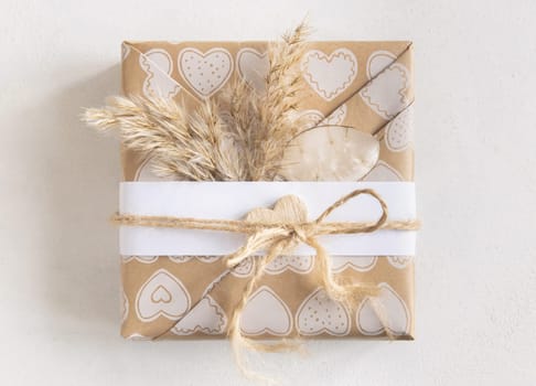 Valentines Day presents wrapped in kraft paper and decorated with heart and pampass grass top view. Spring rustic, cottage chic or bohemian concept