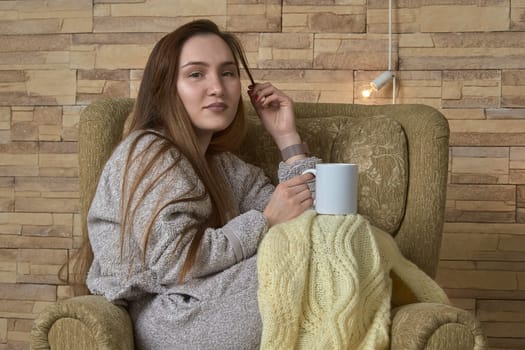 Resting girl in a chair with a cup of tea. High quality photo
