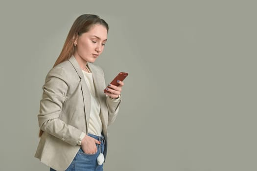 Business woman with a phone in her hands on a gray background. High quality photo
