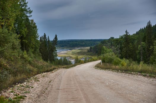 Forest dirt road in the wilderness along the river. High quality photo