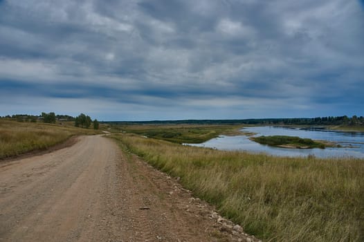 Forest dirt road in the wilderness along the river. High quality photo