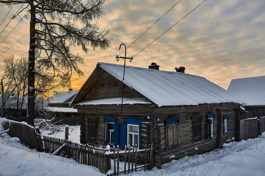 Village hut in winter at sunset. High quality photo