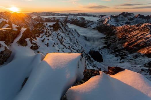 Shot of snowy mountains in winter morning sunlight. Sun rising in High Tatras in wintertime with copy space. Scenery of white landscape in sunrise.