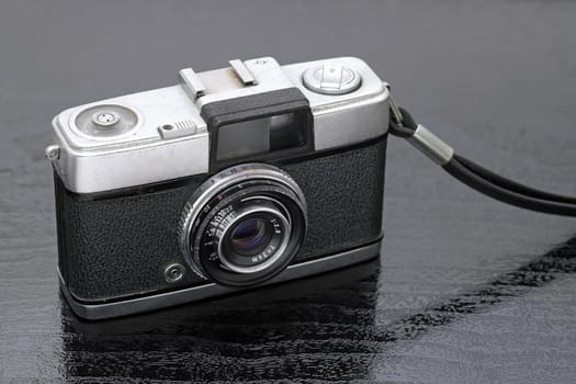 close up of old film camera on black background