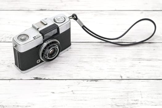 old film camera on a white wooden background