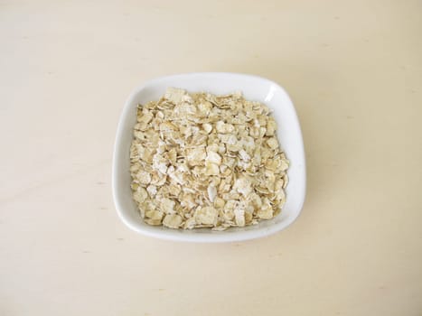 Fine rolled oats flakes on a wooden board
