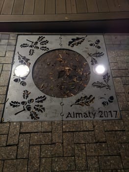 ALMATY, KAZAKHSTAN - NOVEMBER 8, 2019: Side grating, perforated with images of oak leaves and acorns with the inscription Almaty 2017.
