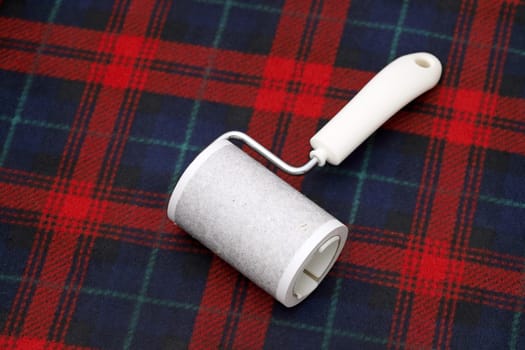 close up of used sticky roller cleaning, housework and housekeeping concept