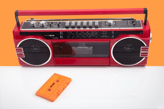 Red vintage Tape player isolated on orange and white background