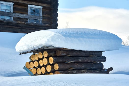 A stack of logs covered with slate under the snow. High quality photo