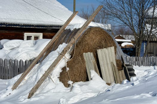 Haystack under the snow in the village. High quality photo