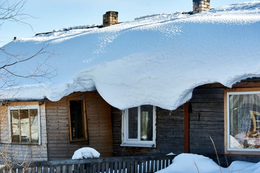 The roof of the house is covered with snow. High quality photo