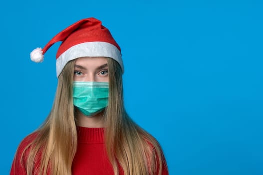 Girl in a medical mask with a Santa hat. High quality photo