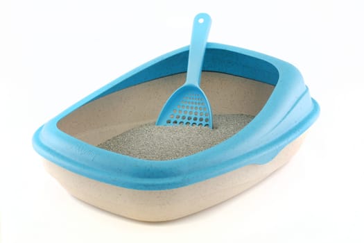A side view of a cat litter tray with scoop